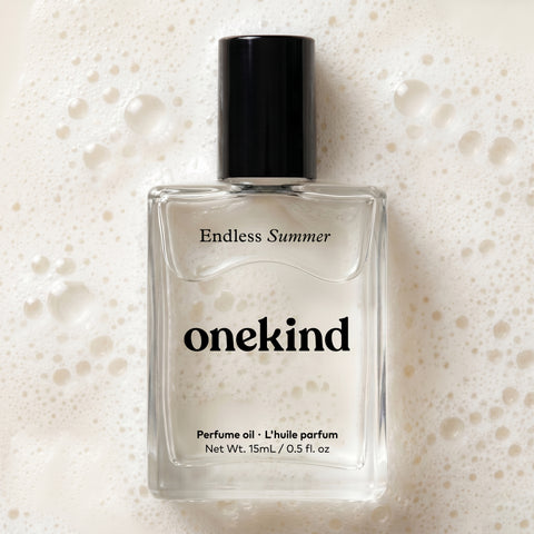 Onekind Endless Summer perfume oil bottle laying on coconut milk