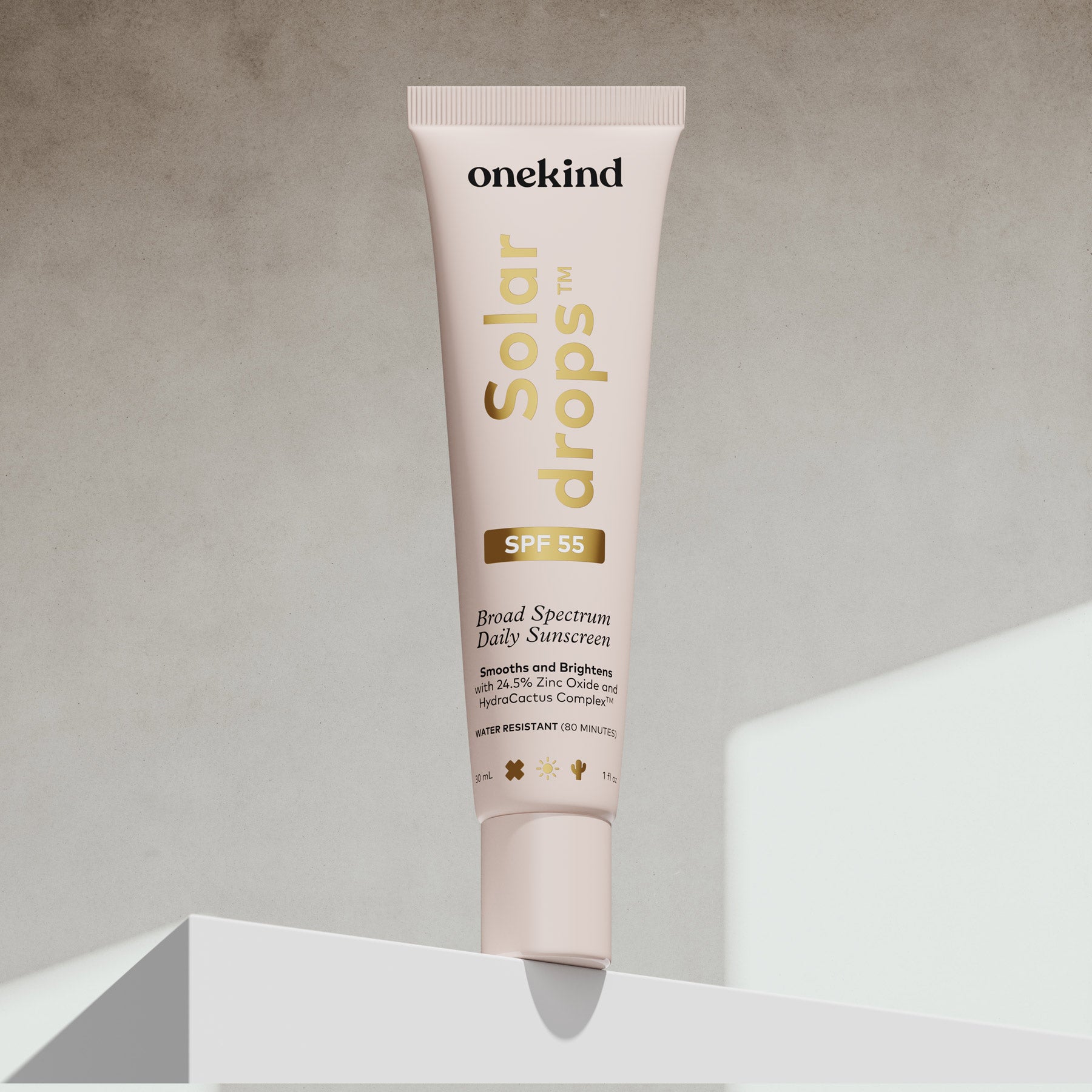OneKind Solar Drops sunscreen tube on a neutral background